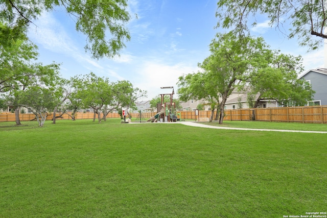 view of property's community with a playground and a lawn