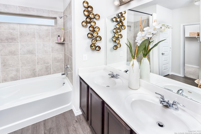 bathroom featuring tiled shower / bath, vanity, and wood-type flooring