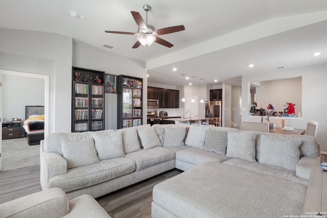 living room featuring lofted ceiling, ceiling fan, hardwood / wood-style flooring, and sink