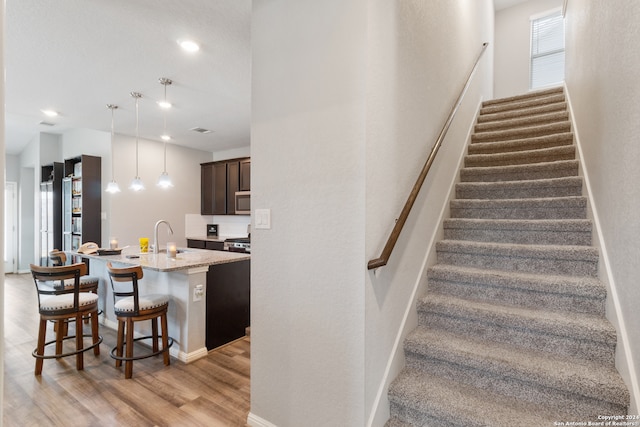 staircase featuring sink and hardwood / wood-style floors