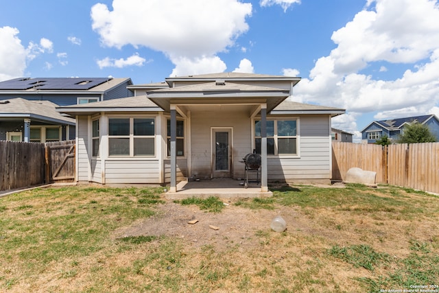 rear view of house with a patio area and a lawn