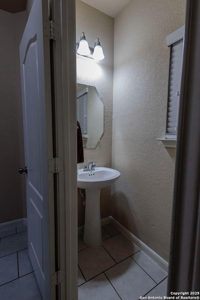 8446 Buckhorn Parke, San Antonio, TX 78254 - bathroom featuring baseboards, a textured wall, tile patterned flooring, and a sink