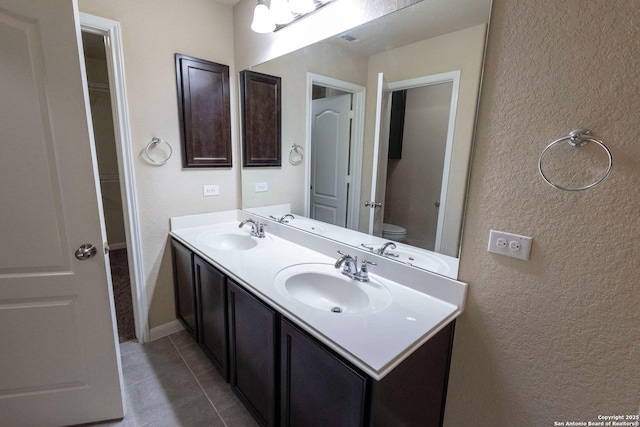 8446 Buckhorn Parke, San Antonio, TX 78254 - bathroom with a textured wall, double vanity, a sink, and toilet