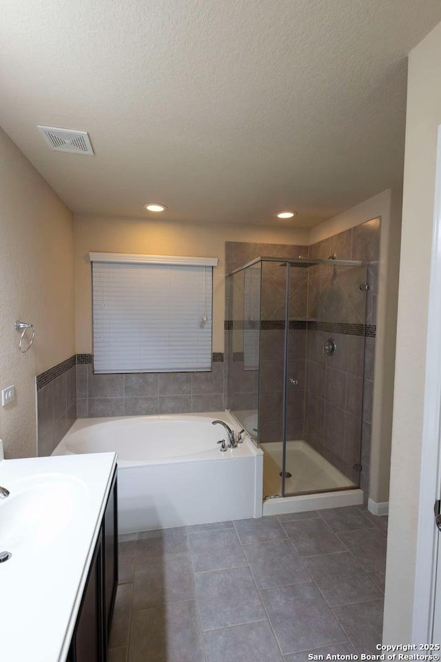 8446 Buckhorn Parke, San Antonio, TX 78254 - bathroom featuring a stall shower, vanity, a textured ceiling, a bath, and visible vents