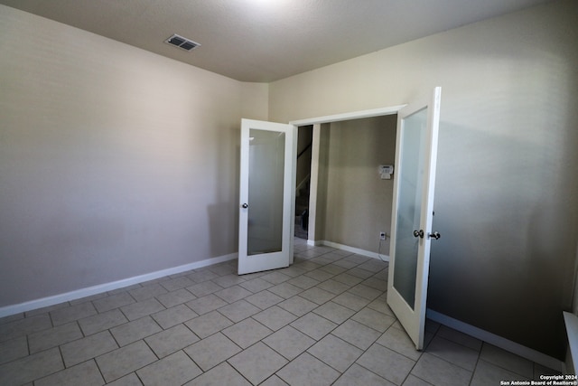 spare room with french doors and light tile patterned flooring