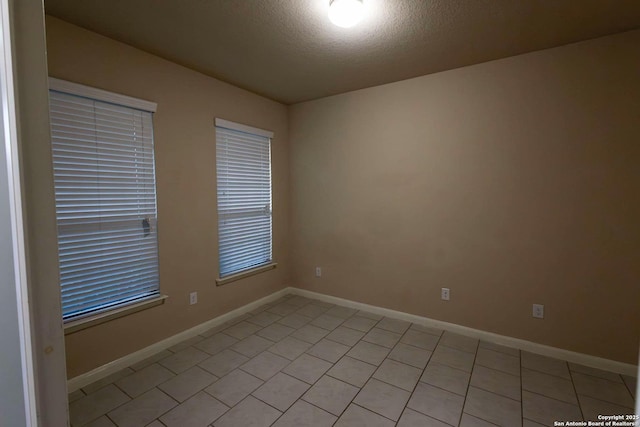 8446 Buckhorn Parke, San Antonio, TX 78254 - empty room featuring baseboards, light tile patterned floors, and a textured ceiling