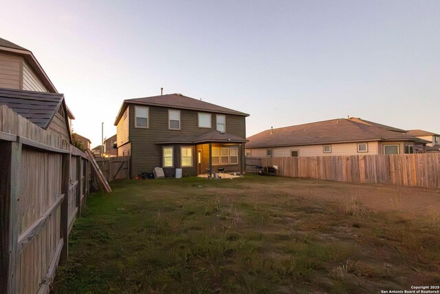 8446 Buckhorn Parke, San Antonio, TX 78254 - back of house at dusk with a fenced backyard and a yard