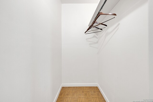 spacious closet with light parquet flooring