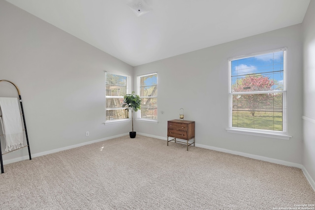 unfurnished room featuring carpet flooring and lofted ceiling