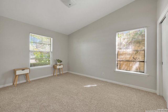 empty room featuring vaulted ceiling and carpet