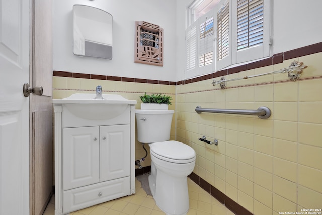 bathroom with tile patterned flooring, vanity, tile walls, and toilet