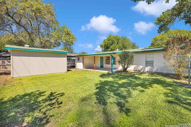 rear view of house featuring a lawn and a patio area