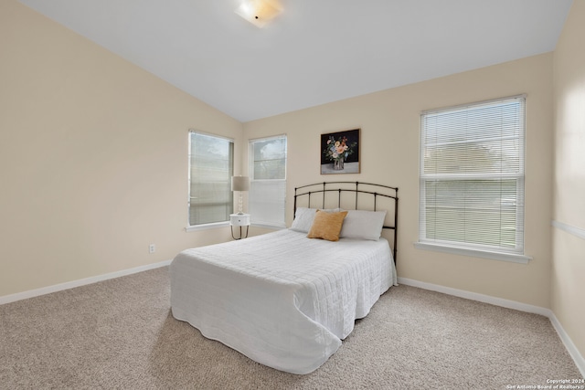 carpeted bedroom with lofted ceiling