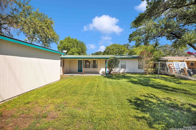 rear view of house with a yard and a patio