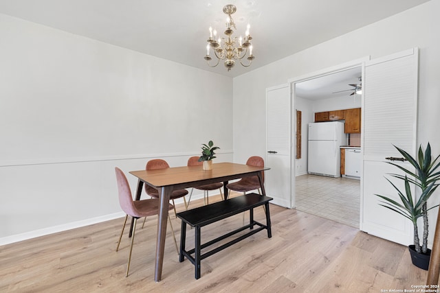 dining space with light wood-type flooring and ceiling fan with notable chandelier