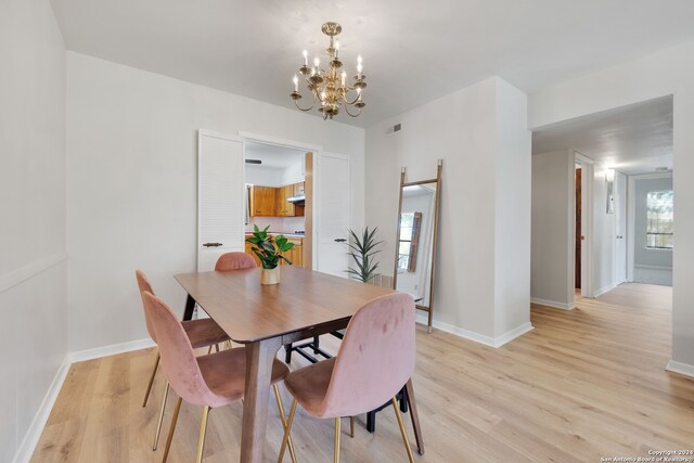 dining area featuring an inviting chandelier and light hardwood / wood-style flooring