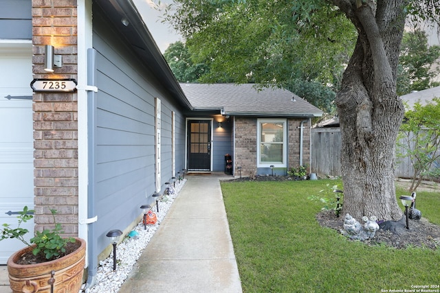 view of exterior entry featuring a yard