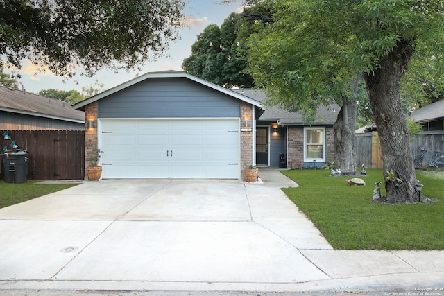 ranch-style house featuring a lawn and a garage