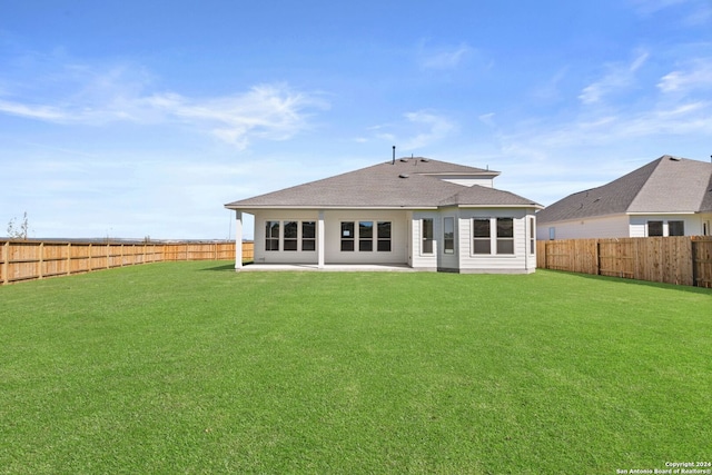 rear view of house featuring a lawn and a patio area