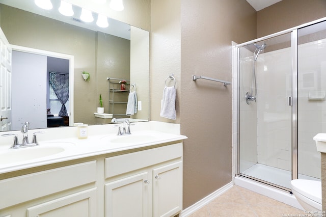 bathroom featuring a shower with door, vanity, toilet, and tile patterned floors