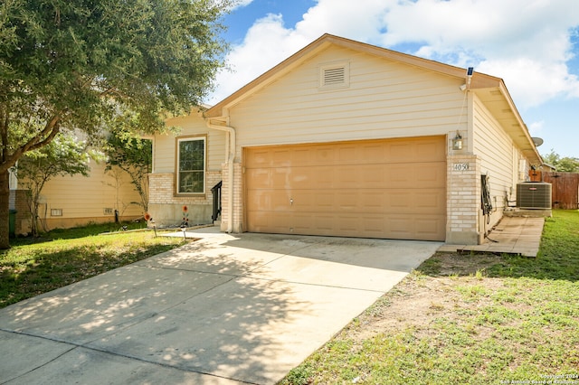 ranch-style house with a garage, central AC unit, and a front lawn