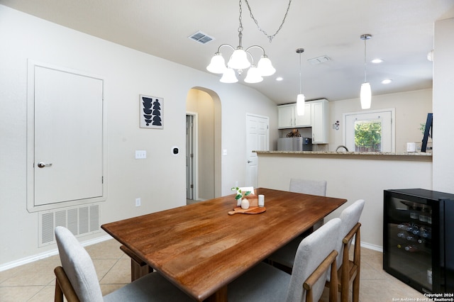 dining room featuring beverage cooler, light tile patterned floors, and a notable chandelier