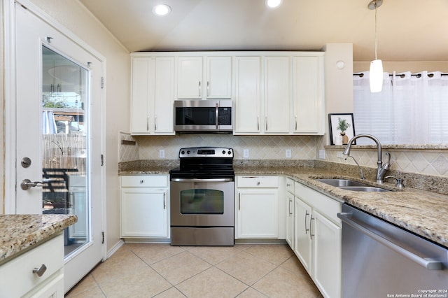 kitchen featuring white cabinets, decorative light fixtures, stainless steel appliances, sink, and lofted ceiling