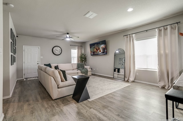 living room featuring hardwood / wood-style floors and ceiling fan