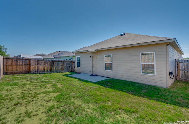 rear view of house featuring a yard and a patio