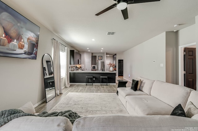 living room featuring ceiling fan and light hardwood / wood-style floors