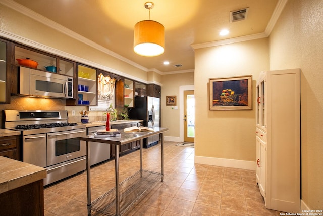 kitchen featuring stainless steel appliances, light tile patterned flooring, hanging light fixtures, and crown molding