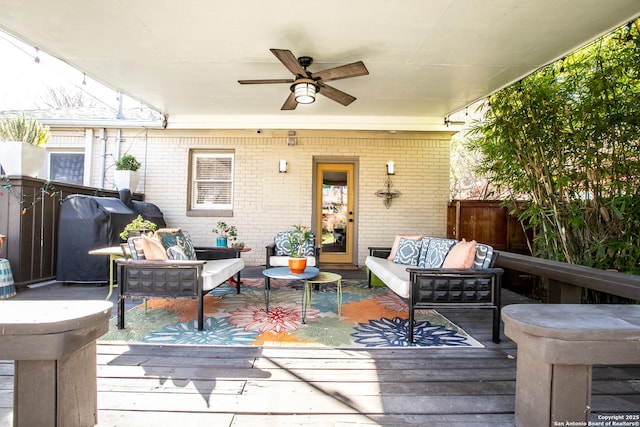 wooden terrace featuring an outdoor living space, ceiling fan, and a grill