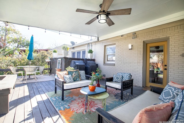 wooden deck with grilling area, outdoor lounge area, and ceiling fan