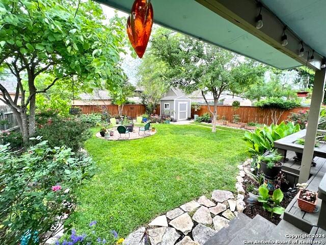 view of yard featuring a storage shed and a fire pit