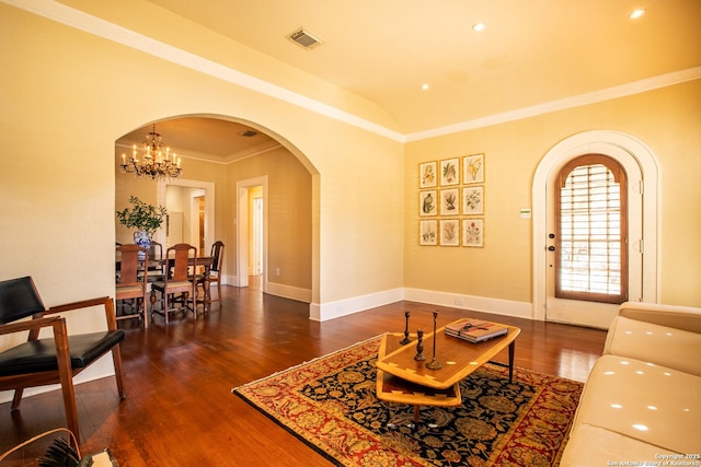 living room with dark wood-type flooring, ornamental molding, a chandelier, and vaulted ceiling