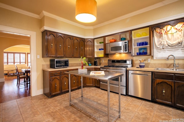 kitchen featuring crown molding, sink, light tile patterned floors, and stainless steel appliances