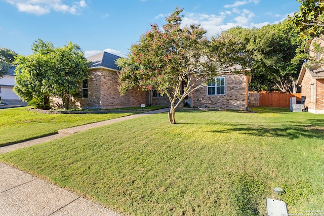 view of property hidden behind natural elements featuring a front lawn