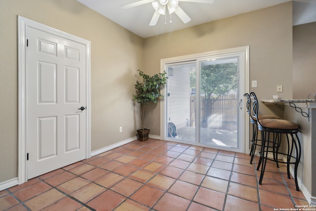 doorway with ceiling fan and tile patterned flooring