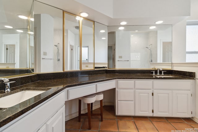 bathroom with a shower, vanity, and tile patterned floors