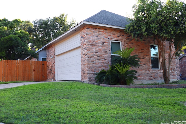 view of side of home with a garage and a lawn