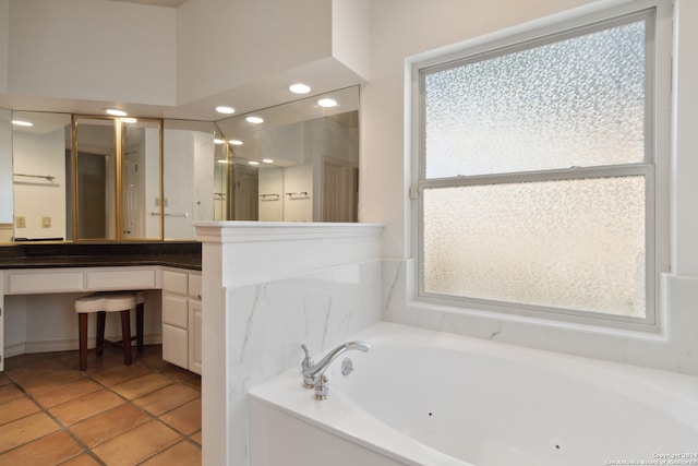 bathroom with tile patterned floors, a washtub, and vanity