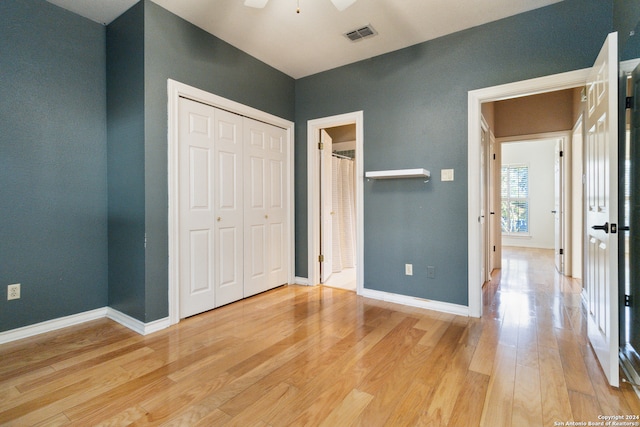 unfurnished bedroom with wood-type flooring, ceiling fan, and a closet