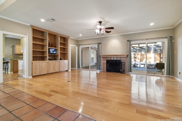 unfurnished living room featuring ceiling fan, a fireplace, light hardwood / wood-style floors, and crown molding