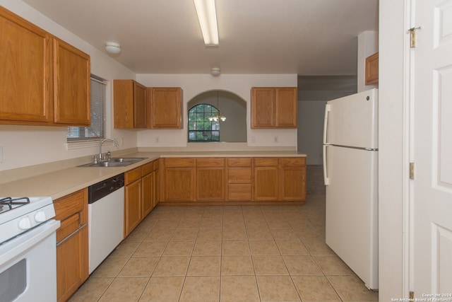 kitchen with sink, white appliances, an inviting chandelier, and light tile patterned flooring