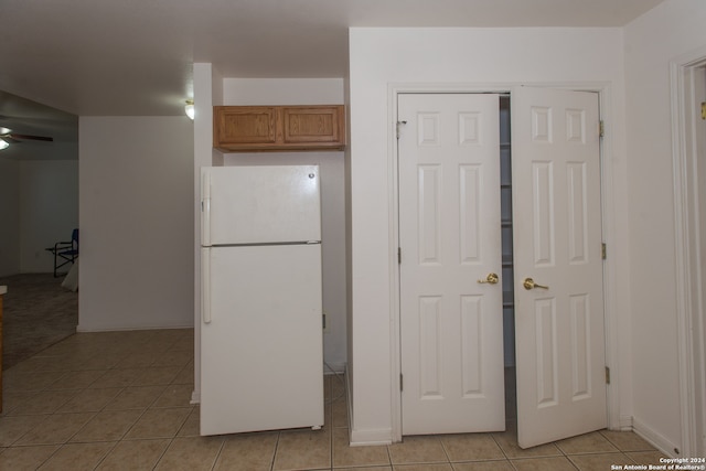 kitchen featuring ceiling fan, white fridge, and light tile patterned flooring