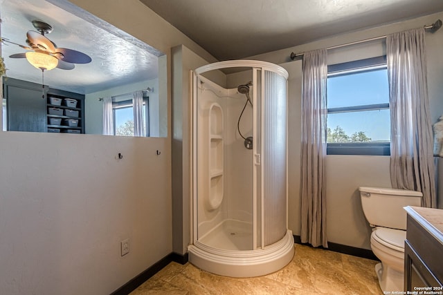 bathroom featuring toilet, walk in shower, vanity, a textured ceiling, and ceiling fan