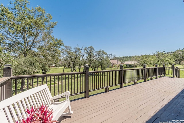 wooden terrace featuring a yard