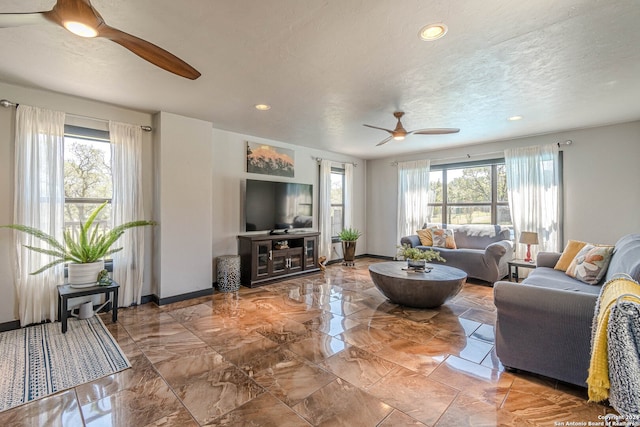 living room with a textured ceiling, a healthy amount of sunlight, and ceiling fan