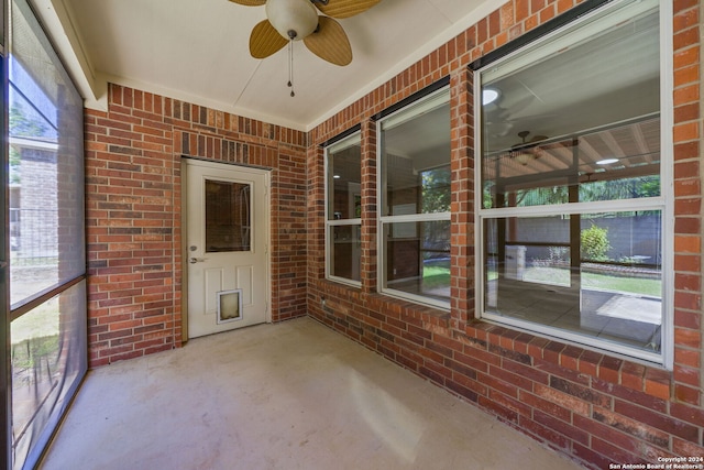 unfurnished sunroom featuring a healthy amount of sunlight and ceiling fan