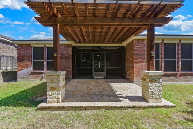 property entrance with a lawn, a patio, and a pergola